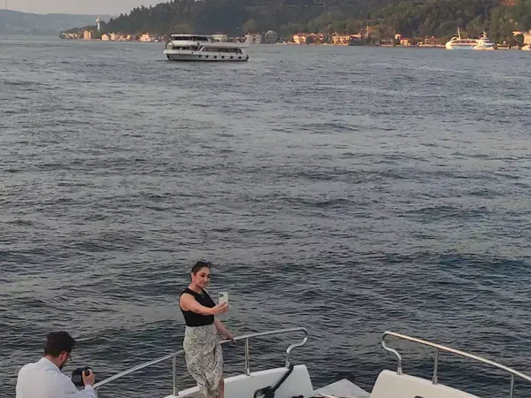 Guests on a yacht bow at sunset by the Bosphorus Bridge