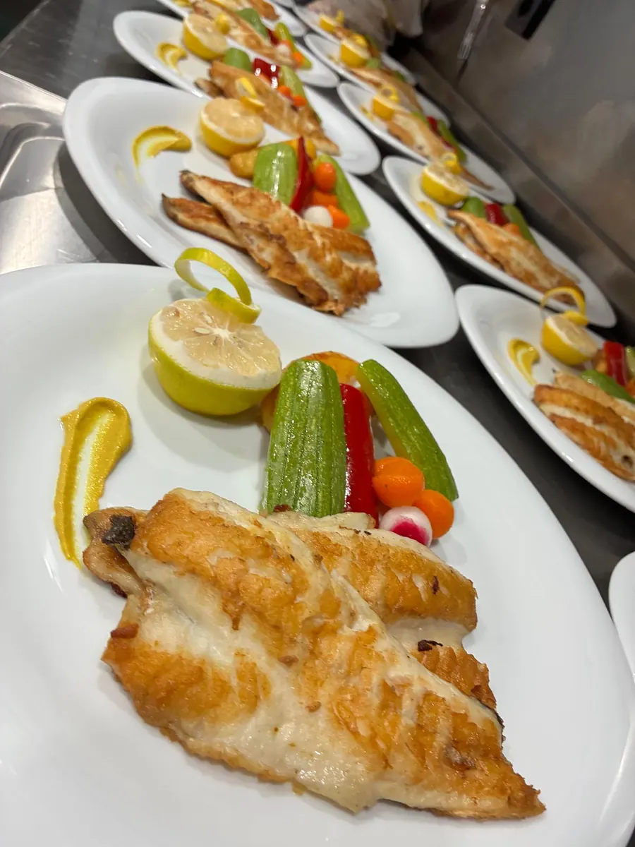 Fresh fish with lemon and vegetables on a yacht