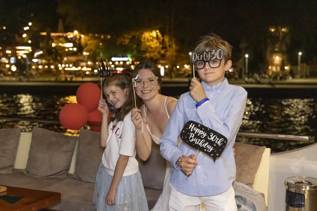 Children with birthday props on a yacht at night