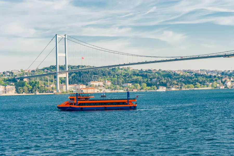 El barco del crucero con cena en el Bósforo cerca del puente