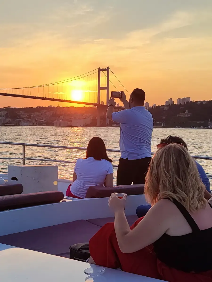 Guests on a yacht with the Bosphorus Bridge in the evening
