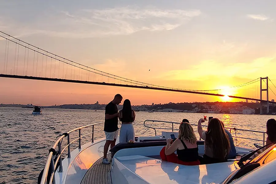Guests on a yacht at sunset by the Bosphorus Bridge