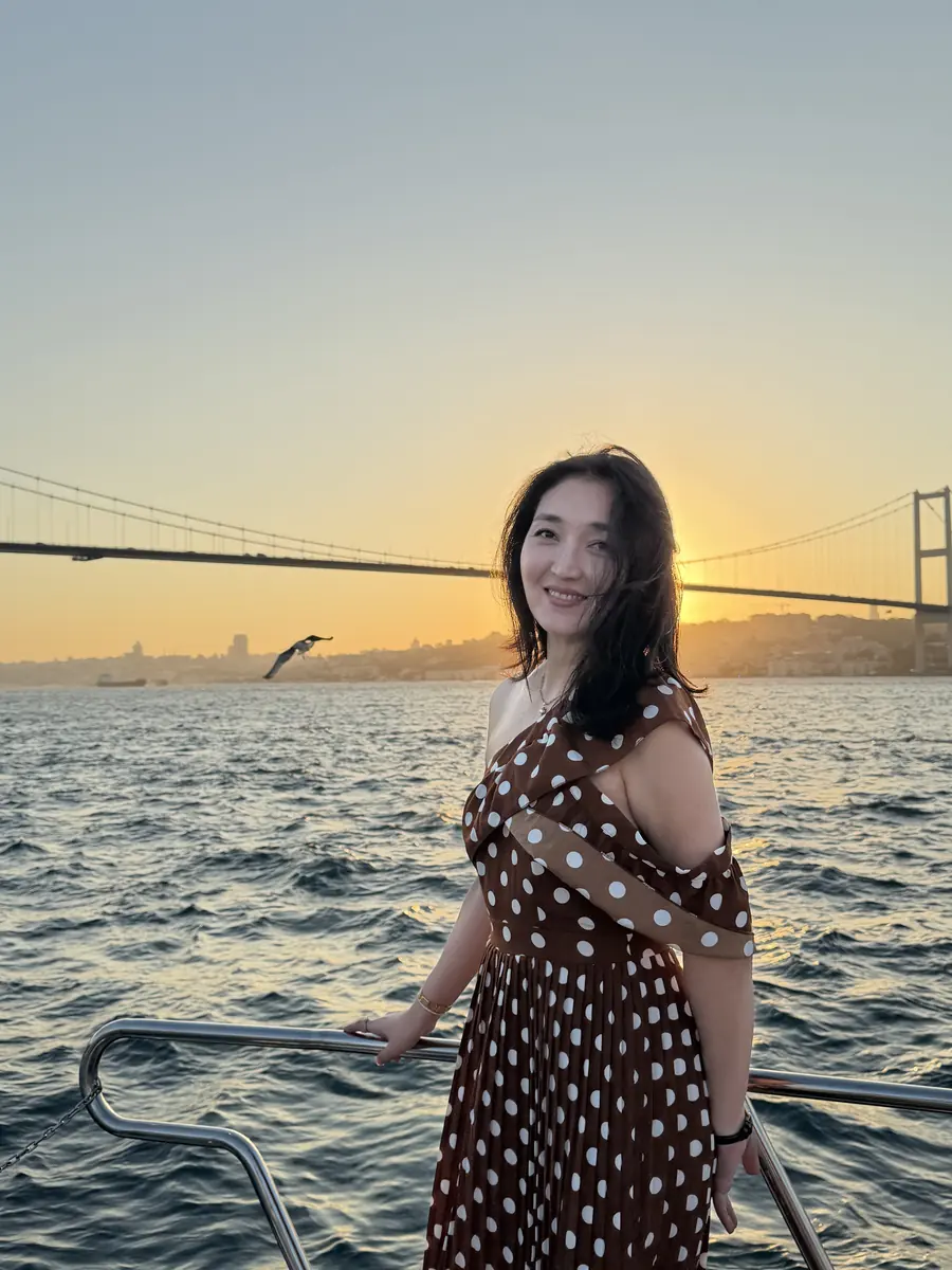 Guest on deck at sunset with the Bosphorus Bridge behind