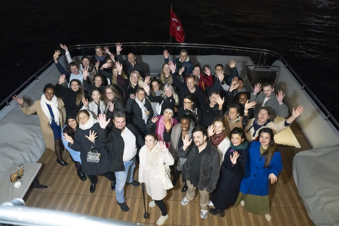 Large group celebrating on the deck of a yacht at night