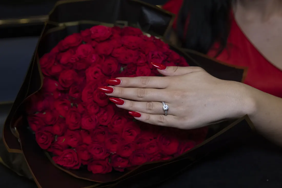 Engagement ring and a bouquet of red roses