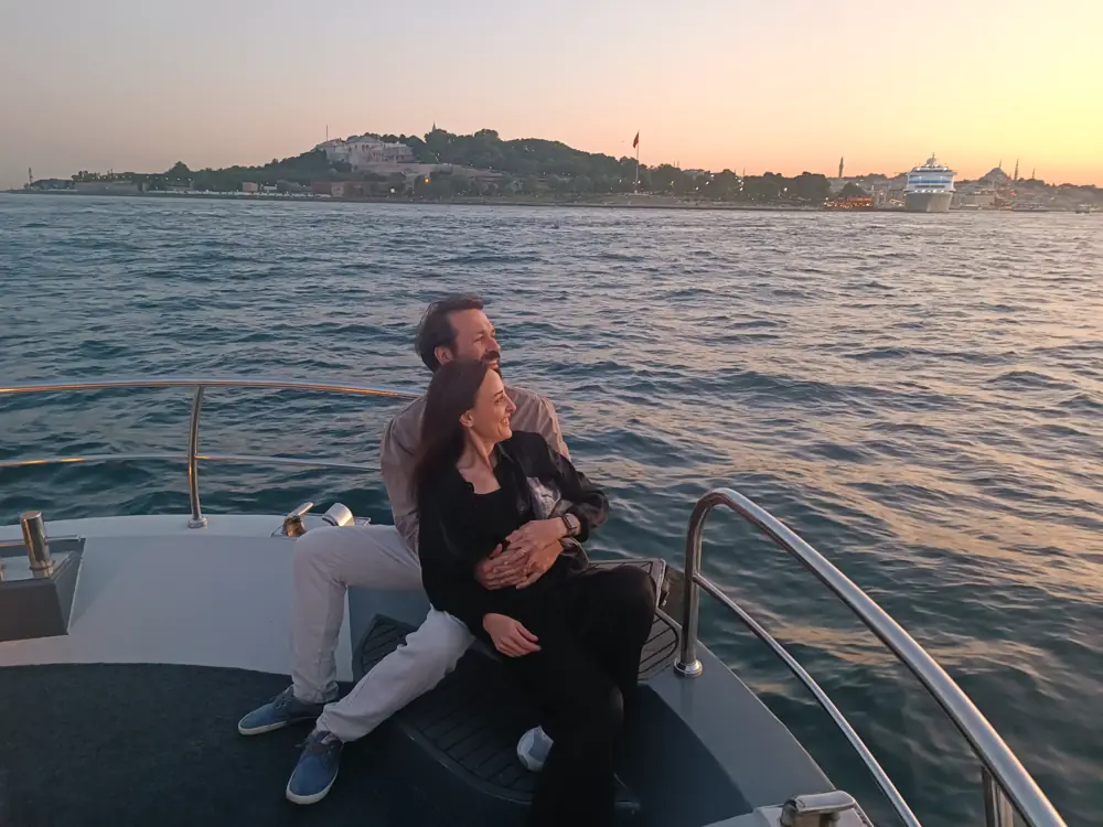 Couple enjoying the sunset on the bow of a private yacht