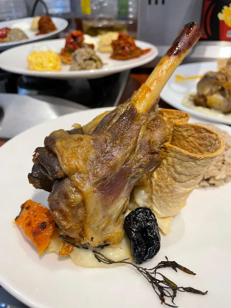 Slow-cooked lamb shank prepared by the chef on board