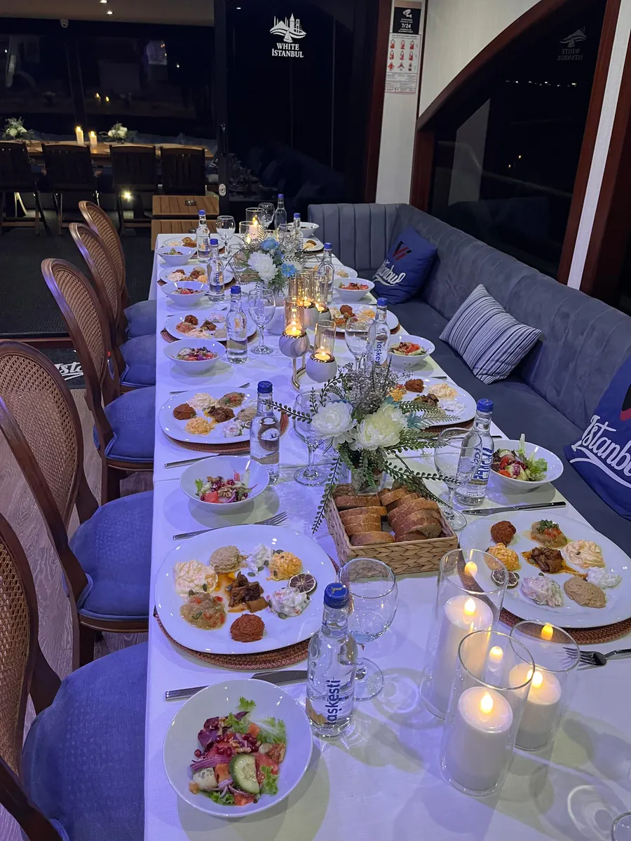 Long dinner table with candles and flowers on a private yacht