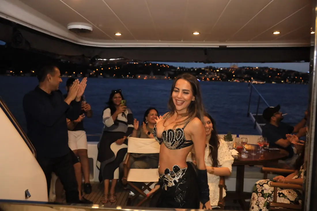 Belly dancer with guests on a yacht at night