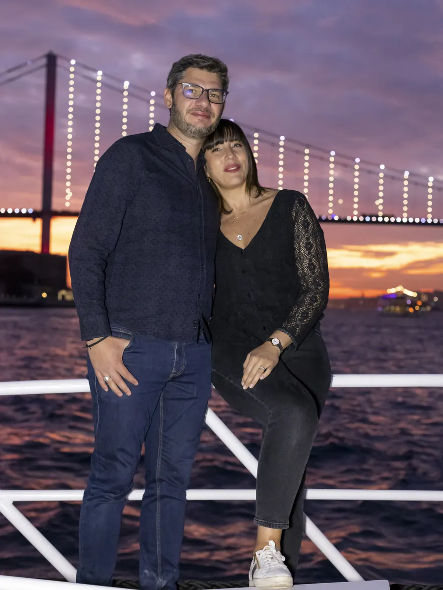 Couple on a yacht with the lit Bosphorus Bridge