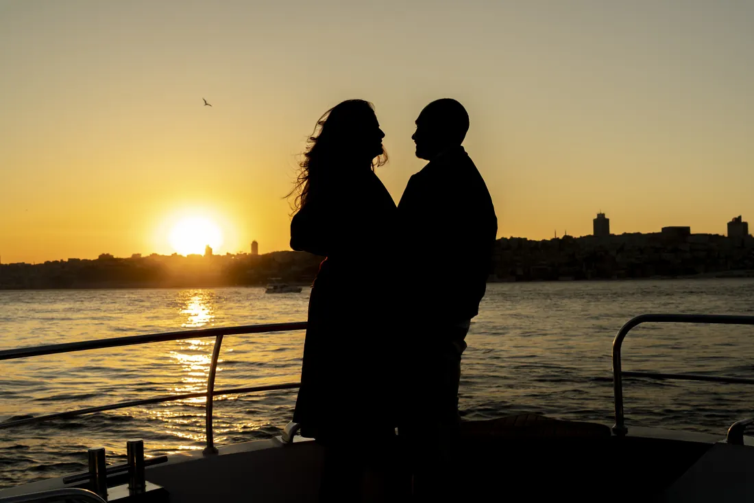 Couple in silhouette against the sunset over Istanbul on a private yacht