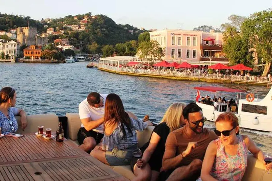 Guests on the yacht deck near Ortaköy in the evening