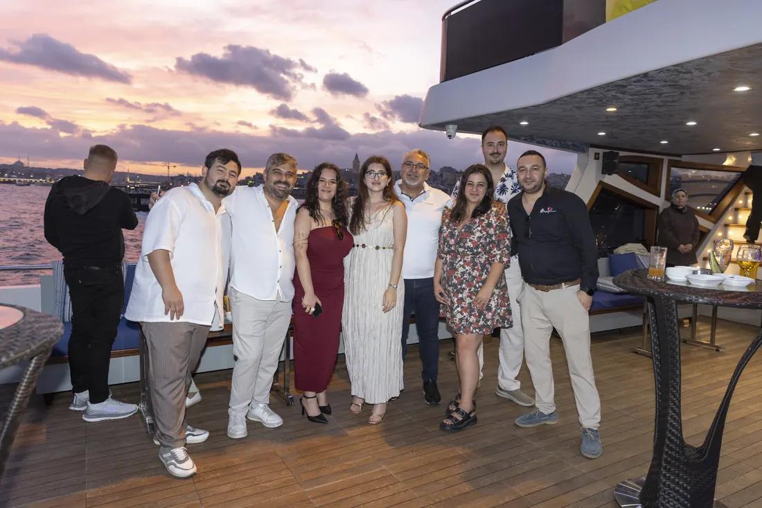 Team photo on the deck of a yacht at sunset