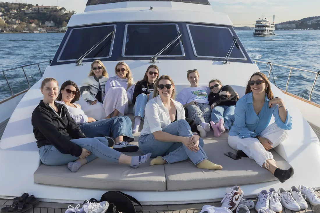 Team relaxing on the bow of a yacht on the Bosphorus