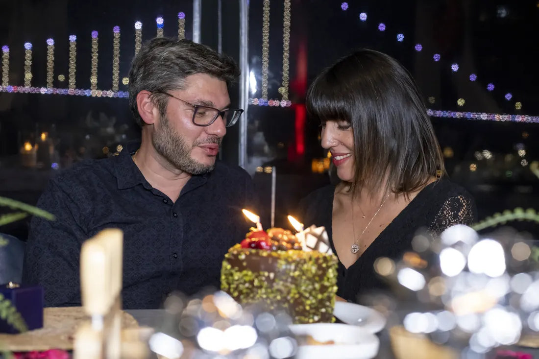 Couple with a cake and candles on a yacht at night