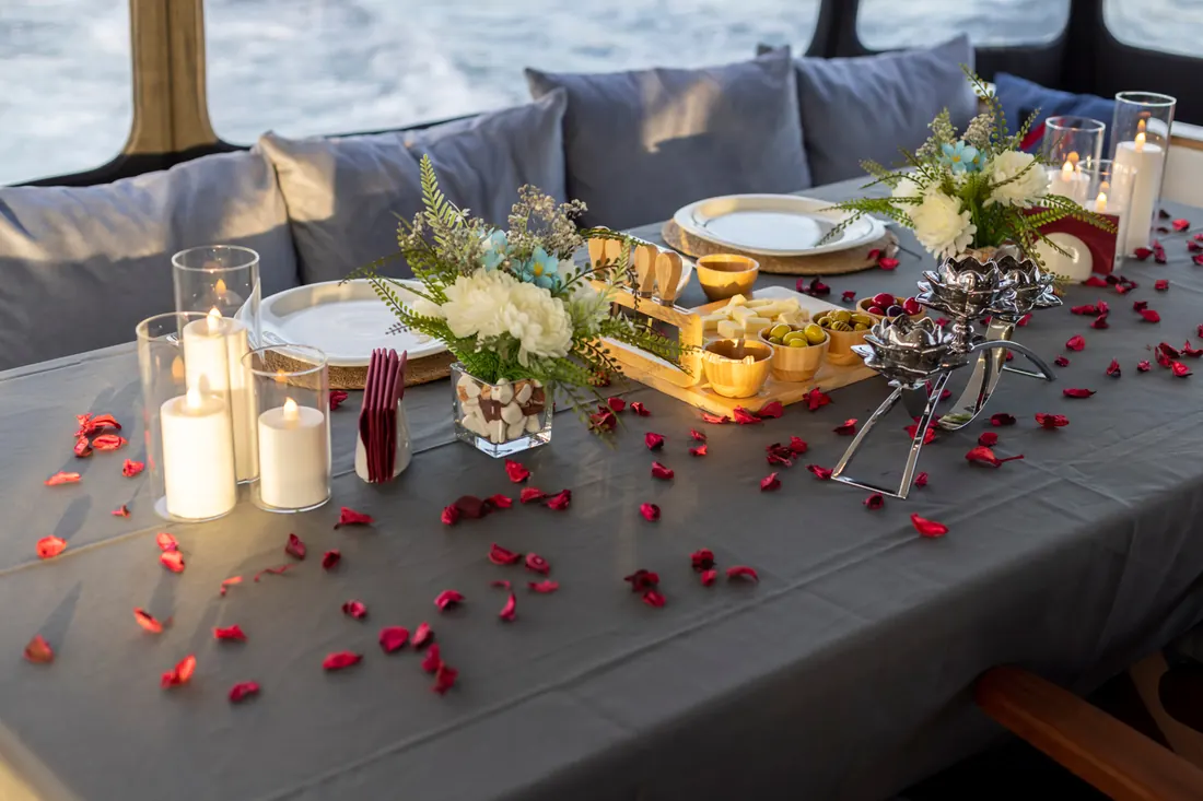 Table with candles and rose petals on a yacht