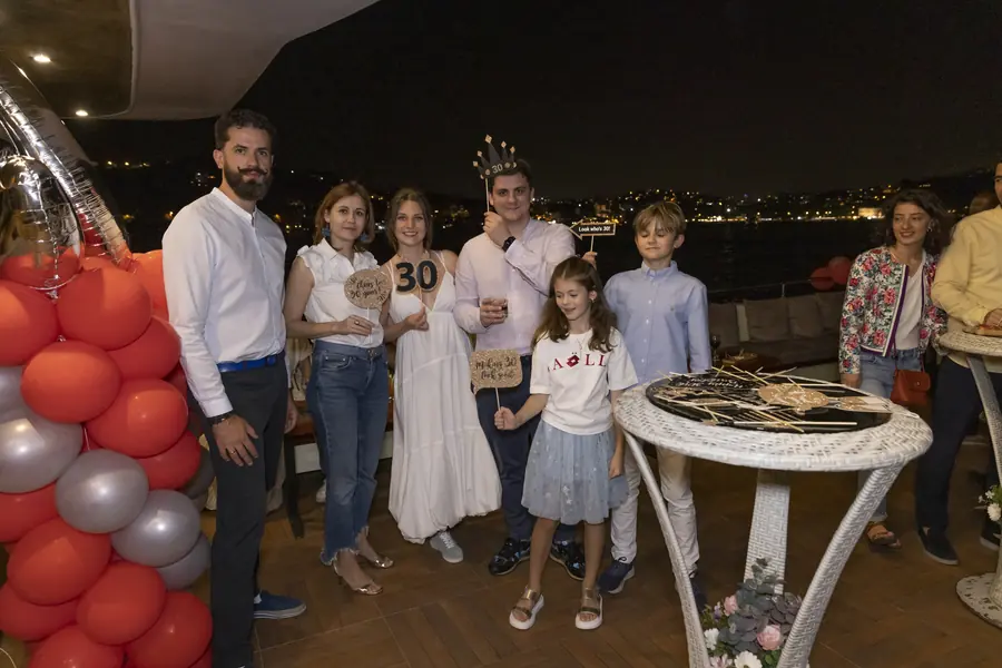 Birthday party guests with balloons on a yacht deck