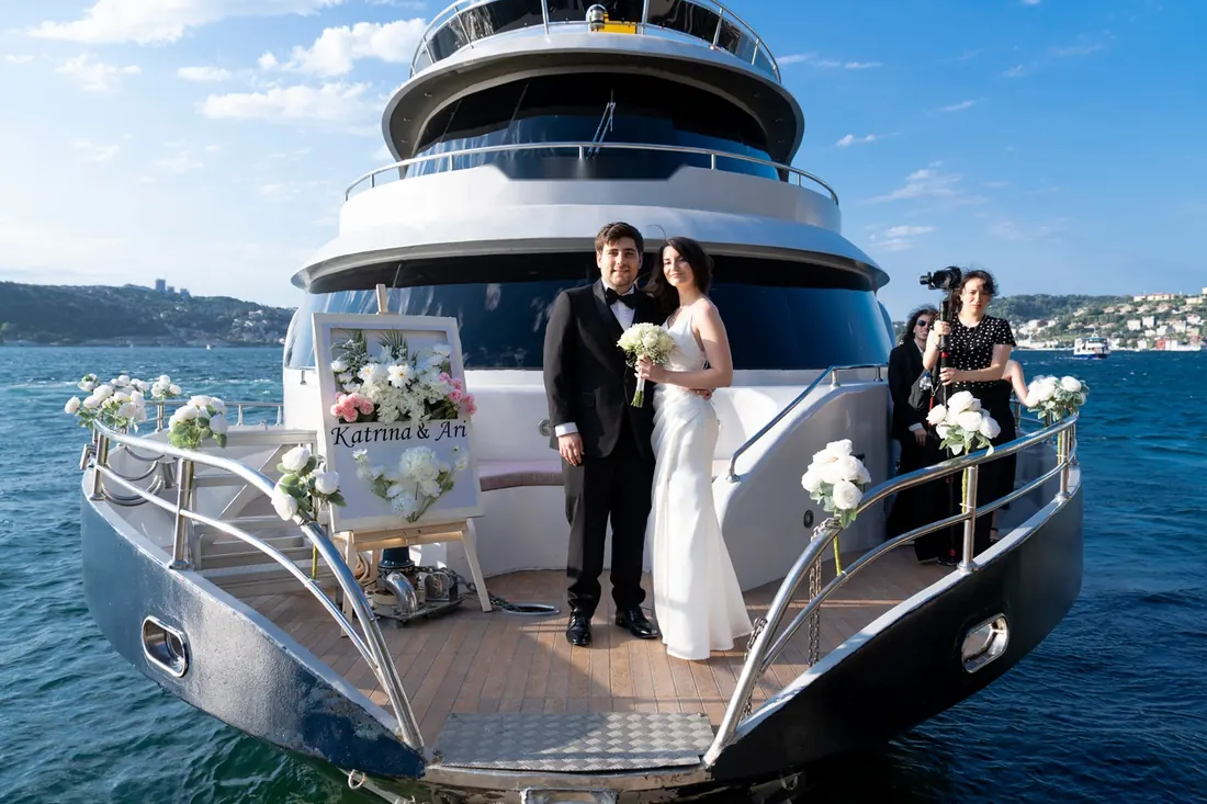 Bride and groom on a yacht bow decorated with flowers