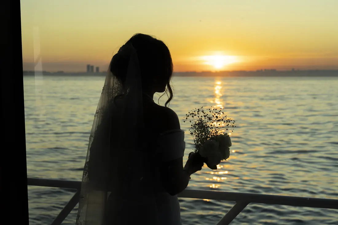 Bride silhouetted against the sunset on a yacht