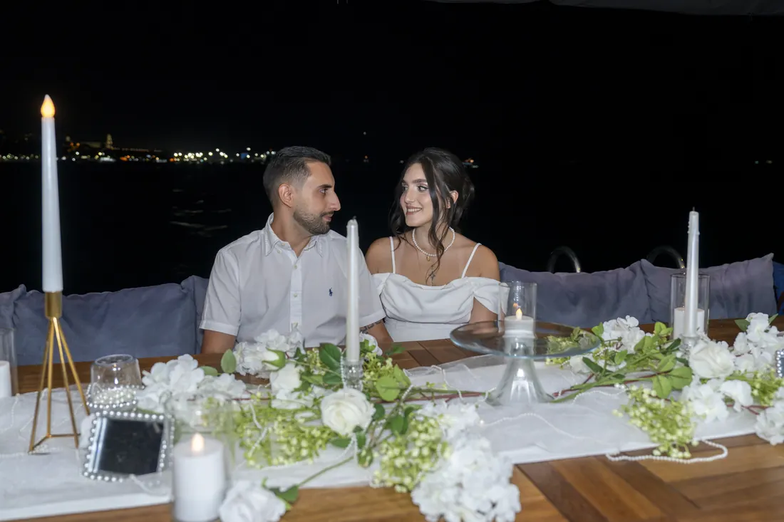 Newlyweds at a candlelit table on a yacht