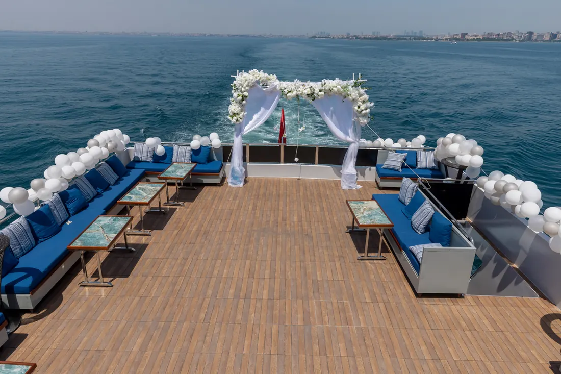 Yacht deck set for a wedding ceremony with a flower arch