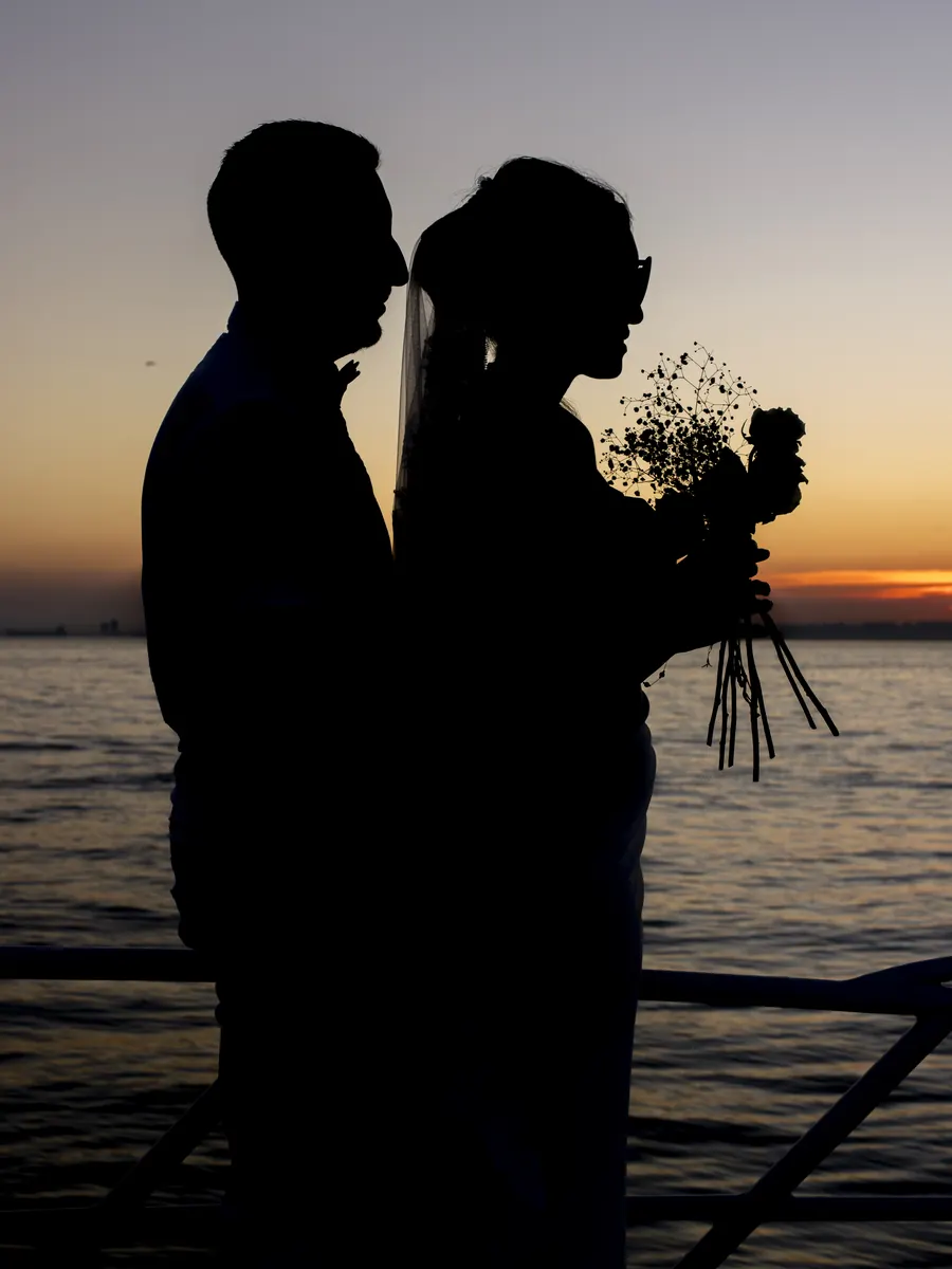 Couple silhouetted against the sunset on a yacht