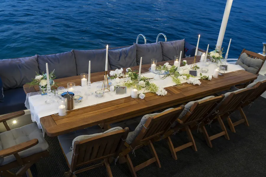 Wedding table with white flowers and candles on a yacht deck