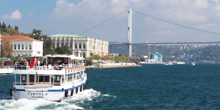 Sightseeing boat passing waterside mansions on the Bosphorus in Istanbul