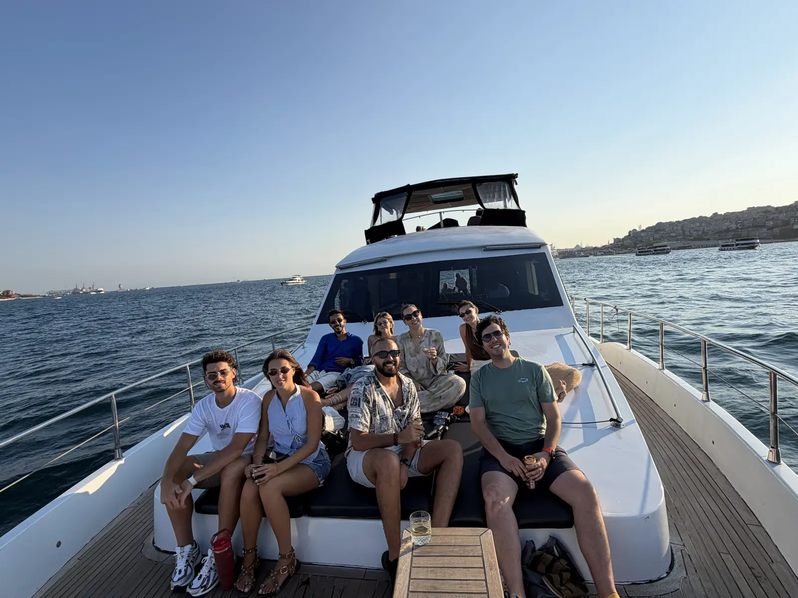 Private Bosphorus cruise by day with a group aboard a chartered boat passing Dolmabahçe Palace in Istanbul